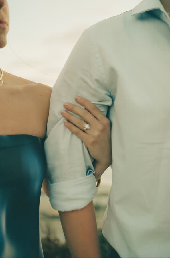 Close-up of Jessica's hand and engagement ring on Dylan's arm
